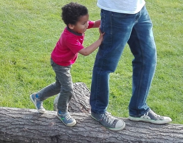 Young boy playing with dad outdoors