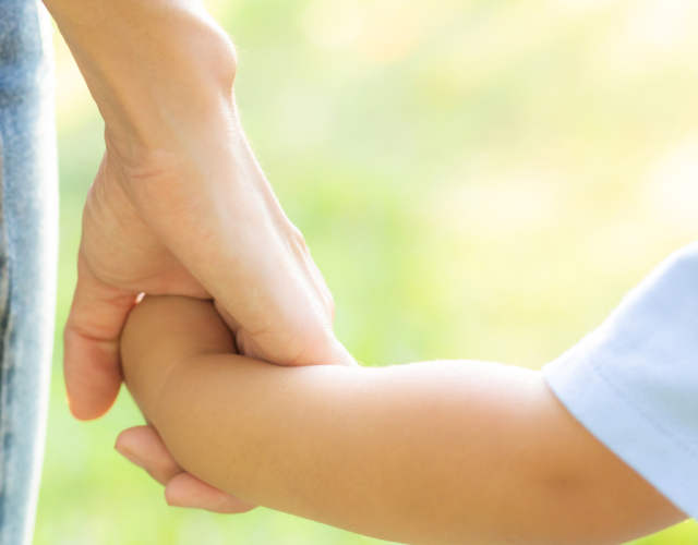 toddler holding their mum hand